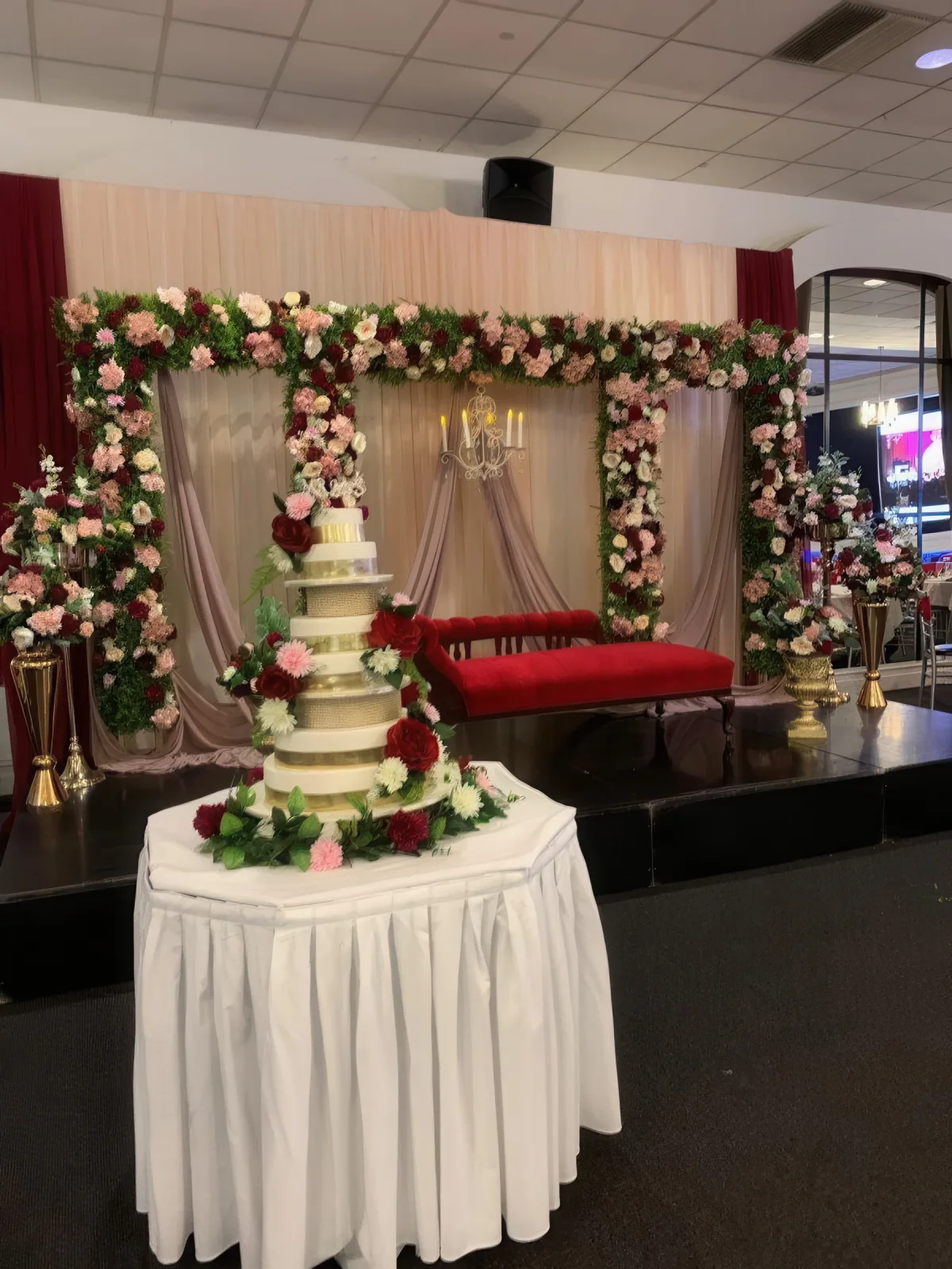 Wedding cake table with floral backdrop styling