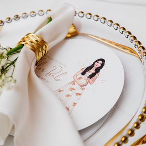 White napkin with gold serviette ring and place card